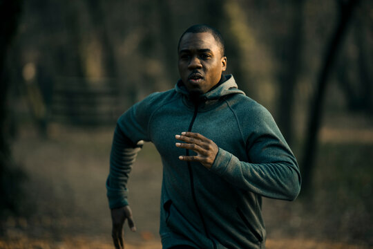 Determined man running on a forest trail