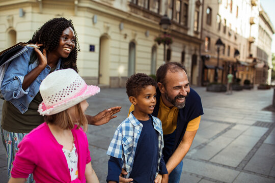 Smiling family with children exploring city street