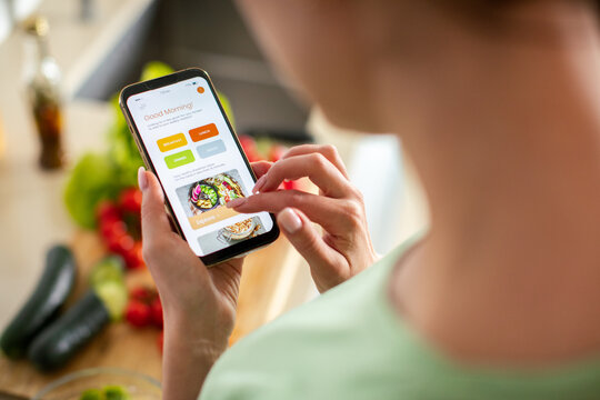 Person using meal planning app in home kitchen