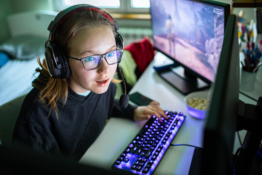 Teen girl playing pc video game at home