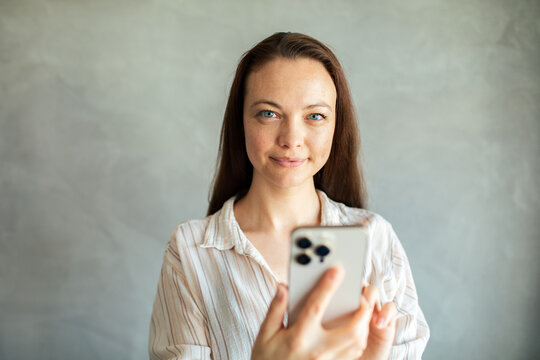 Young woman using smartphone indoors with copy space
