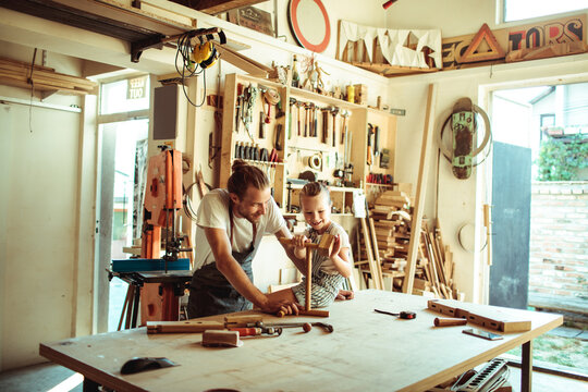 Father and daughter woodworking together in home workshop