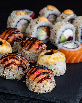 Minimalist Mixed Sushi Rolls on Slate Board with Dramatic Lighting and Copy Space, Vertical Food Photography for Restaurant Menu Design