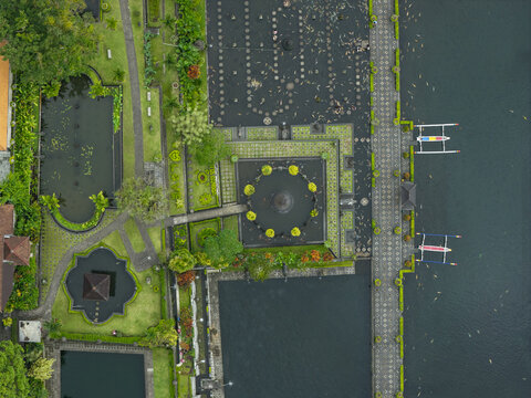 Aerial view of Tirta Gangga water palace featuring ornate fountains, stepping stones, and lush gardens surrounded by tranquil ponds in Kecamatan Abang, Bali, Indonesia.