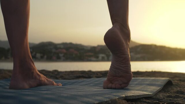 Woman embodies serenity, standing on a blue yoga mat with one foot lifted, basking in the tranquil atmosphere of a beach at sunset, perfect for wellness and yoga marketing.