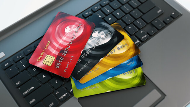 Multi colored credit card standing on laptop keyboard. 3D illustration