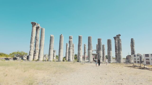 People exploring the historic Roman temple pillars at Uzuncabur&ccedil; ancient city in Turkey.