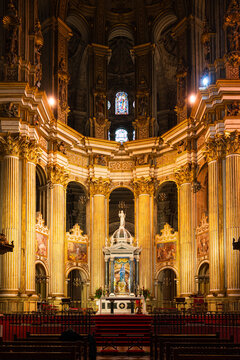 the breathtaking main altar of Malaga Cathedral (Catedral de la Encarnaci&oacute;n), featuring intricate gold details and statues.