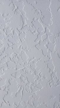 Close-up of white decorative plaster wall texture, knockdown stucco ceiling background