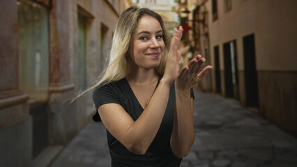 Obraz premium Woman makes finger heart gesture with hands on an old town street, smiling broadly toward camera; playful.