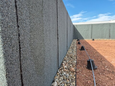 Parapet wall insulated with bituminous waterproofing membrane and gravel border on an extensive green roof under construction.