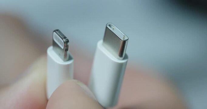Close-up comparison of Lightning and USB-C charging connectors, showing differences between smartphone cable technology.