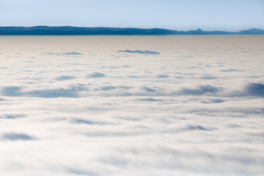 Clouds blanket the landscape like a gentle sea