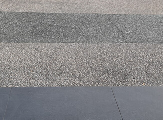 Fototapeta premium Contrast Between Rough Textured Gravel and Smooth Dark Grey Stone Floor Tiles