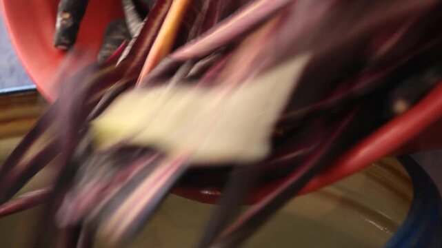 Close-up of freshly sliced purple carrots being poured into a container to prepare traditional Anatolian beverages.