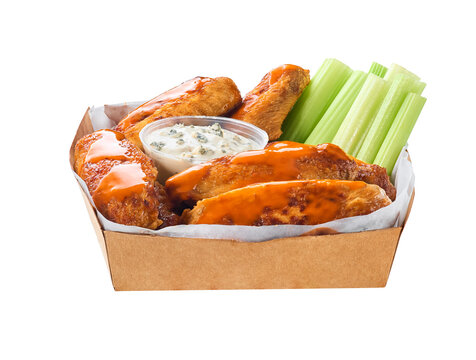 crunchy buffalo chicken wings with celery sticks and blue cheese dipping sauce in paper tray isolated on white background.
