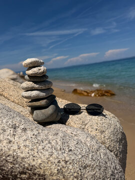 A beautiful photo of round stones against the backdrop of the sea. Glasses against the backdrop of the ocean.