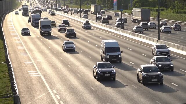 Moscow, July 04, 2026, Busy highway with multiple lanes of traffic. Cars and trucks move steadily in both directions. Sunlight highlights the road surface. Vehicles flow smoothly along the highway