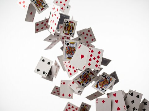 dynamic playing cards falling scattered white background
