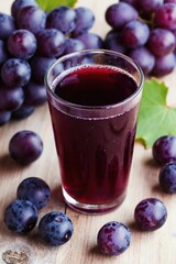 Obraz premium Glass of dark grape juice sits on wooden table with ripe grapes. Freshly squeezed beverage made from whole fruits, healthy drink for refreshment and wellness.