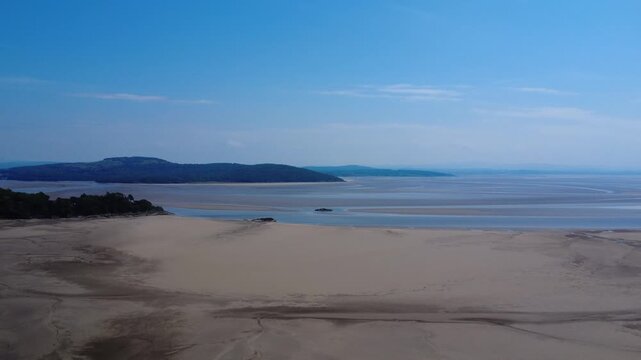 Aerial view of the Beach at Grange Over Sands showing the river Kent running past Arnside and into Morecambe Bay on a sunlit summers day