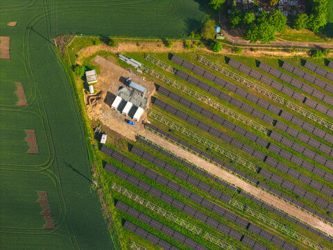 Aerial view of FVE Bohumilice solar power plant with rows of photovoltaic panels, technical equipment, and surrounding green agricultural fields in Klobouky u Brna, Jihomoravsky kraj, Czechia.