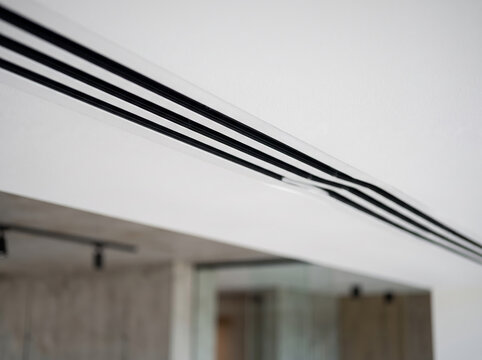 Modern minimalist linear slot diffuser air conditioning vent on a clean white ceiling