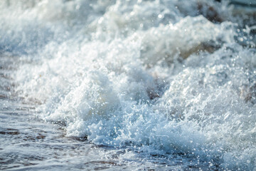 Naklejka premium Close up of powerful foamy sea wave crashing with white spray and water droplets.