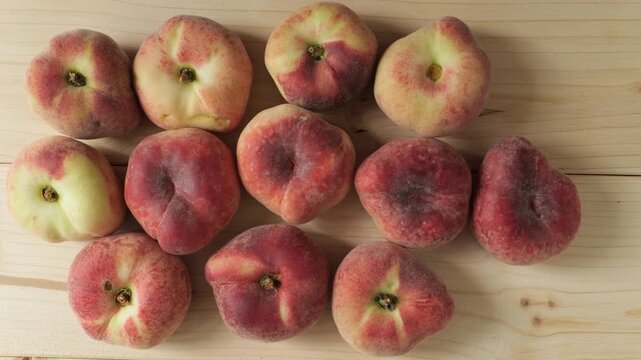 Fresh ripe Saturn peaches on wood