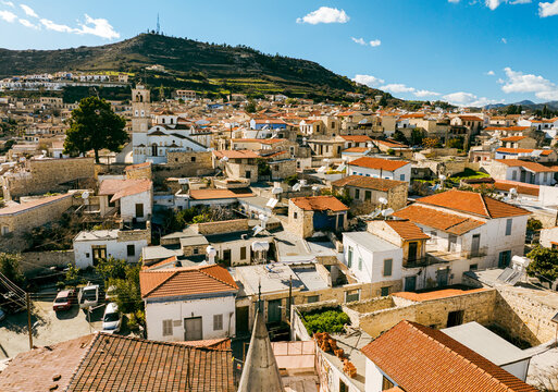 Aerial view of the historic village of Pano Lefkara with traditional stone houses, red-tiled roofs, and a church tower set against rolling hills in Pano Lefkara, Larnaca, Cyprus.