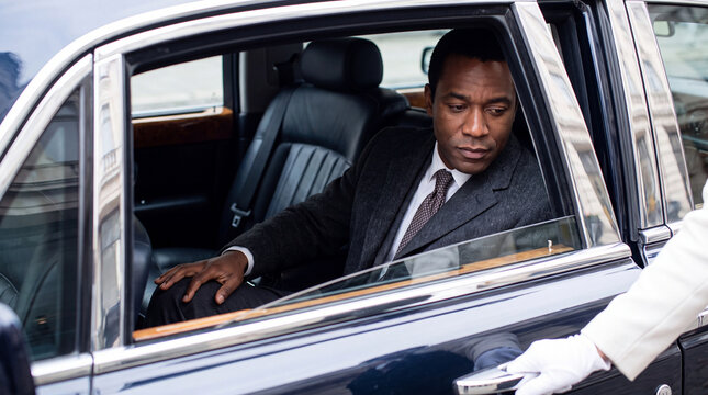 Man settling into luxury car, looking serious