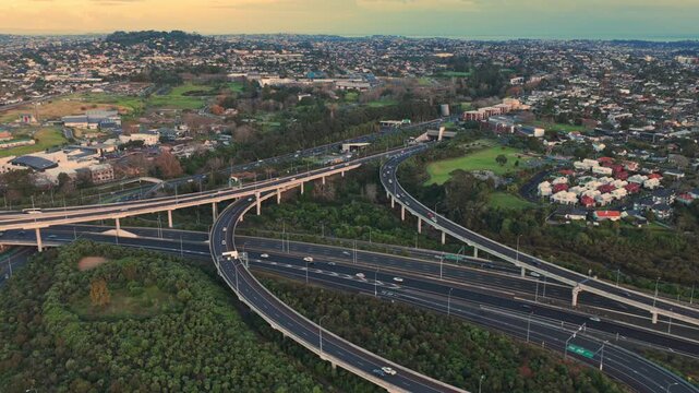 Aerial view of a busy highway interchange of the Northwestern Motorway in Auckland, New Zealand, showcasing urban sprawl and transportation infrastructure