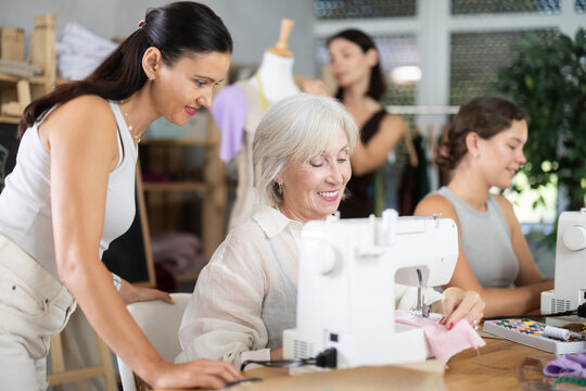 Group of women of different ages sew and work with mannequin during sewing master class