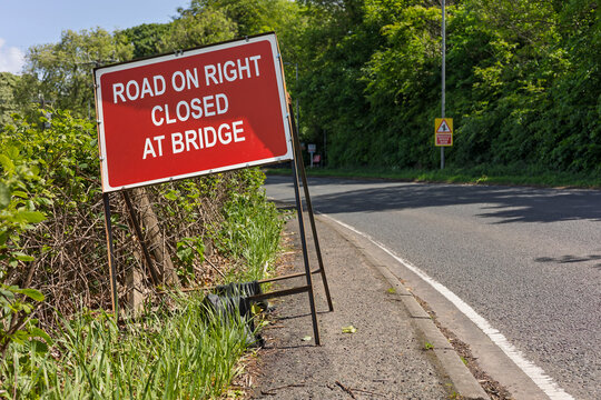 Road on right closed at bridge temporary roadside warning sign