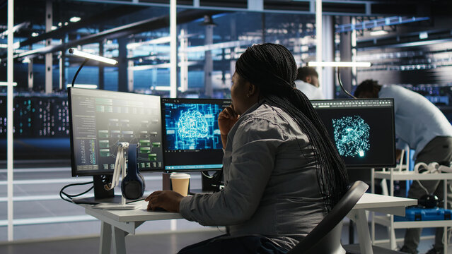 Server facility software engineer applying AI ML models to set up hardware. IT professional works on AI programming tools in server environment, optimizing system.