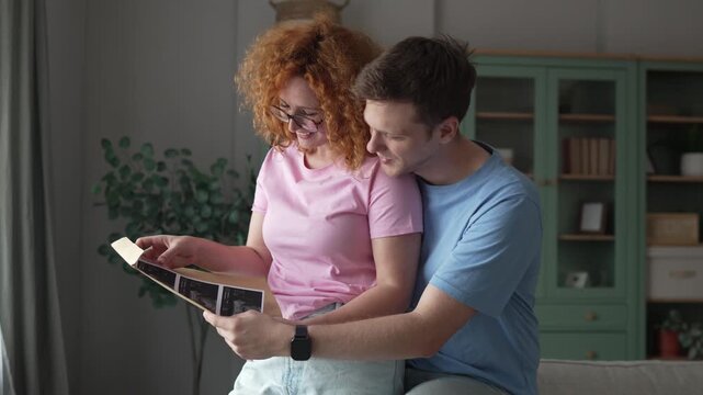 Happy couple looking at first baby ultrasound pictures