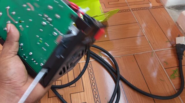 Pushing cooling fan with screwdriver tip for removal from machine