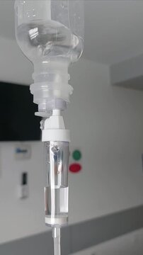 Close up of medical IV drip system with saline solution in hospital