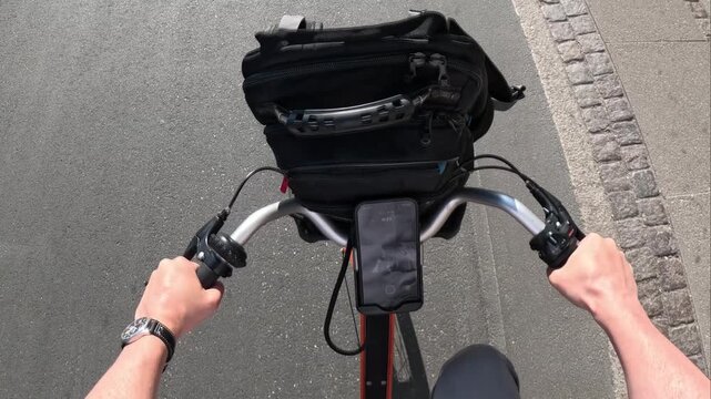 First person view of a man riding a bicycle on a road