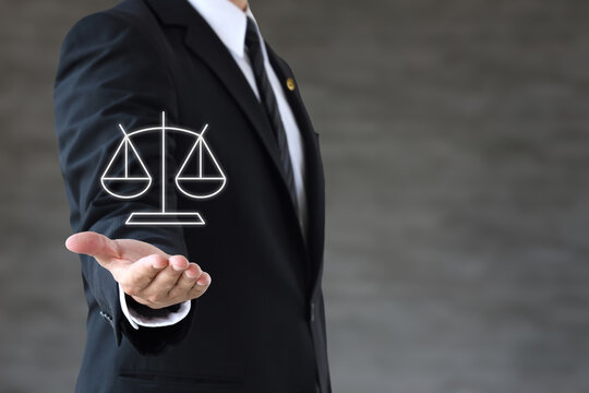 天秤のアイコンを掲げるスーツ姿の男性弁護士―顧問弁護士・企業弁護士のイメージ