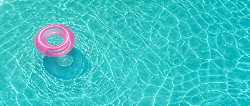 A blue pool with a pink float in it. The pool is full of water and the float is floating on top