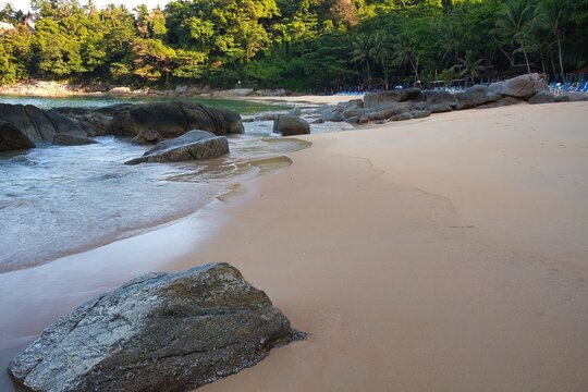 Rocky tropical shoreline with granite boulders and waves at Banana Beach, Phuket, Thailand