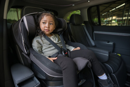 preschool child girl sitting in car seat and looking out of the window, safety baby chair travelling