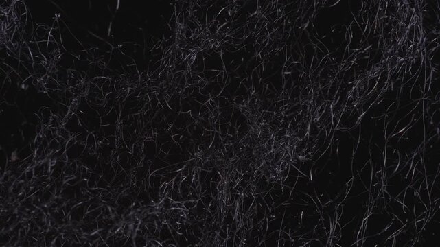 A close up view of burning steel wool igniting and smoldering with a bright orange glow against a dark background.