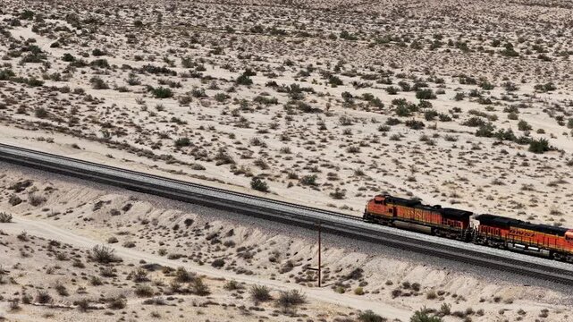 Aerial view of a BNSF freight train traveling on railroad tracks through the California desert