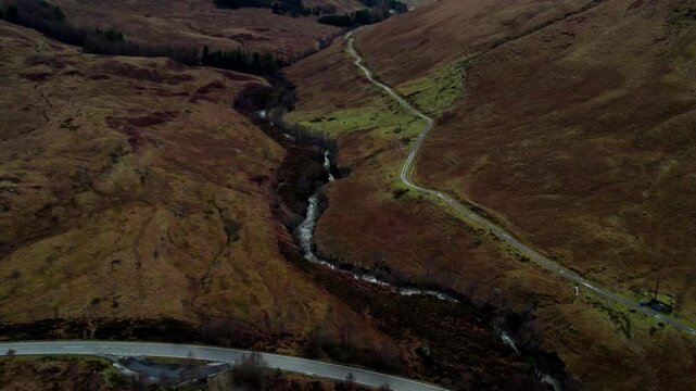 Beautiful slow motion shot of a waterfall in the scottish highlands on a cloudy winter day