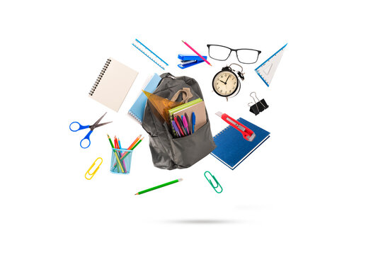 Composition of  grey backpack with various school stationery , notebooks, pencils, scissors, and a clock flying in the air. Isolated on  white background.