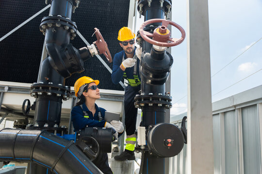 Engineers inspecting industrial piping system, Technicians inspecting industrial cooling system valves and pipes, Engineering team working together on maintenance of industrial water system