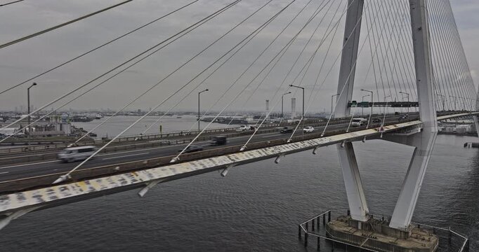 Nagoya Japan Aerial v12 low flyover along Meiko-Chuo Bridge capturing traffic crossing the waterway, port and cityscape of industrial zone on a gloomy day - Shot with Mavic 3 Pro Cine - October 2023