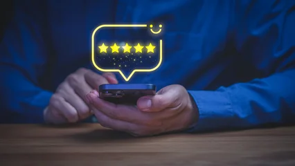 Man holding smartphone with 5 star rating hologram. Online customer review, positive feedback, good review, testimonial and business service satisfaction concept. © ParinPIX